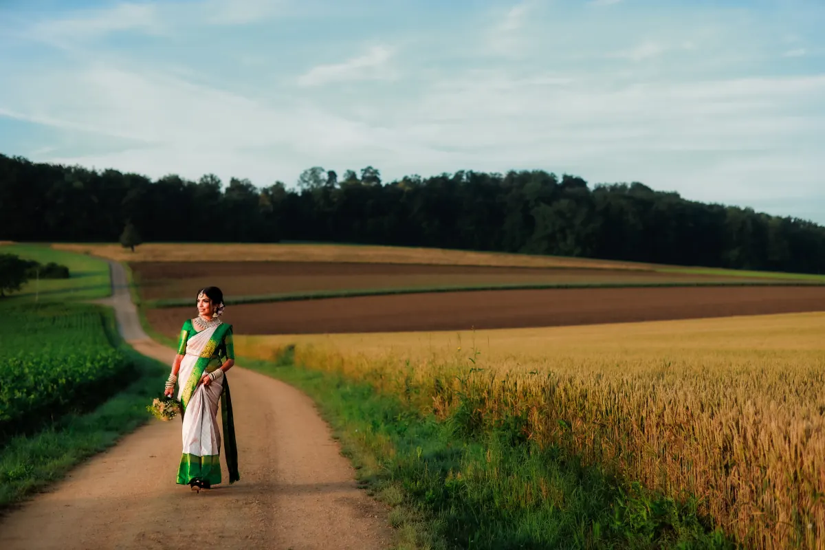A bride on a country road between open fields